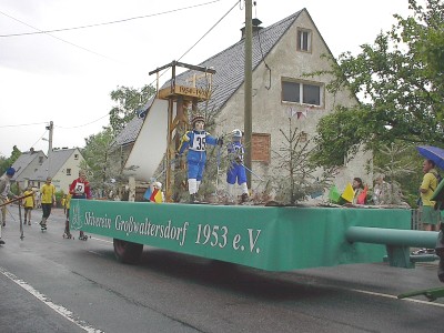 Festwagen mit der Aufschrift „Skiverein Großwaltersdorf 1953 e. V.“: Auf dem grünen Anhänger stehen Figuren in Skikleidung neben einer kleinen Sprungschanze.