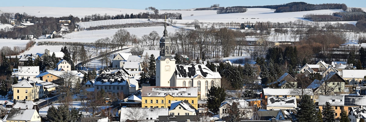 Blick auf Großwaltersdorf im Schnee, etwas weiter herausgezoomt vom Berg aus