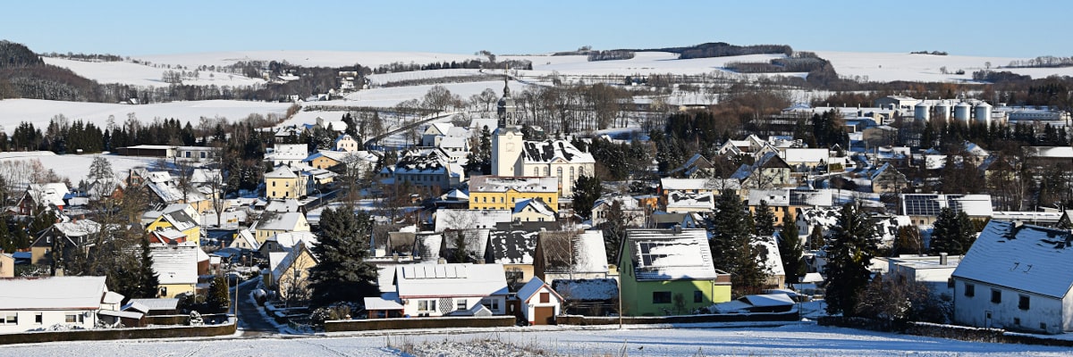 Panoramablick auf das verschneite Großwaltersdorf vom Berg, weit herausgezoomt